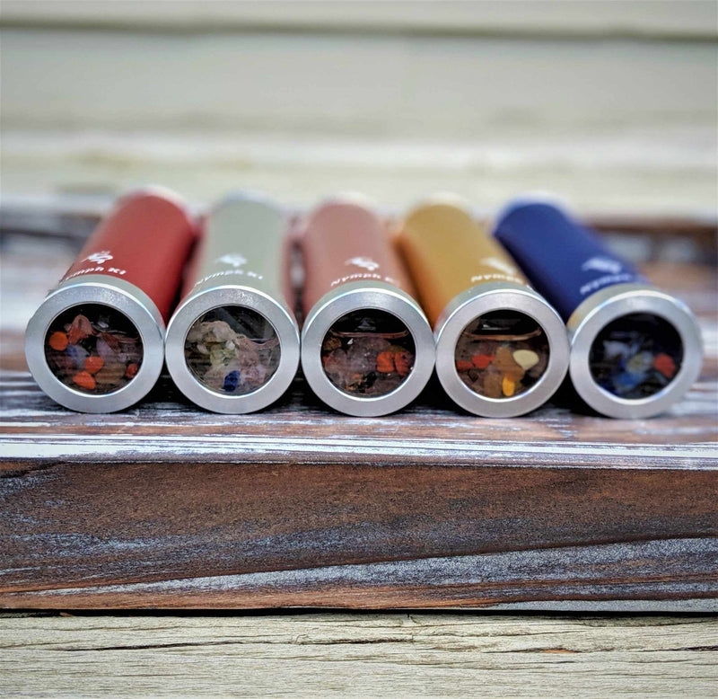 Front view of gemstone-filled kaleidoscope tubes with deep blue at the far right, showcasing stone detail.