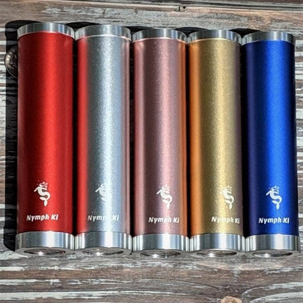 Set of five Nymph Ki kaleidoscopes in red, silver, rose, gold, and blue lined up on rustic wood background.
