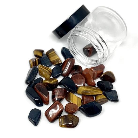 Crystal blend with Red Tiger’s Eye, Gold Tiger’s Eye, and Blue Tiger’s Eye stones spilling from a glass jar on white background.

