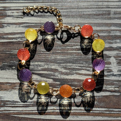 Colorful gumdrop-inspired bracelet with gold tone adjustable chain and dangling charms.