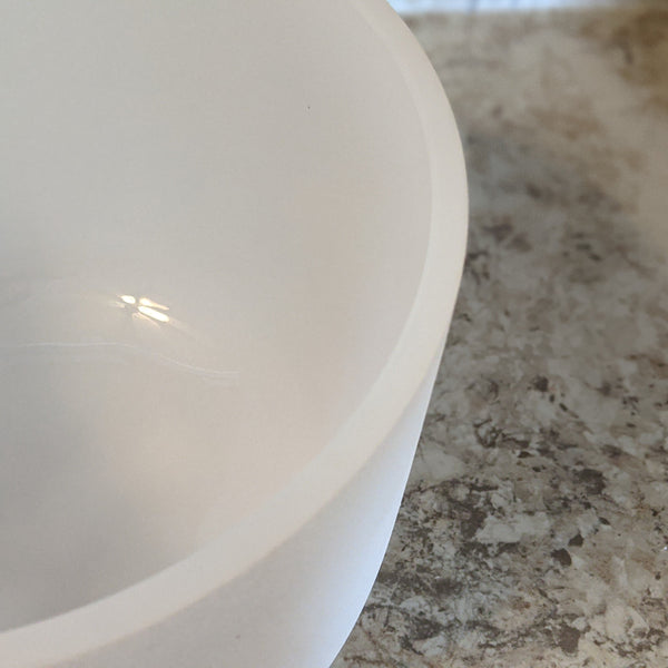 Top-down angle of a crystal singing bowl showing smooth rim and thickness.