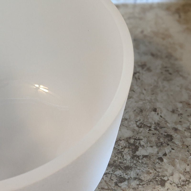 Top-down angle of a crystal singing bowl showing smooth rim and thickness.