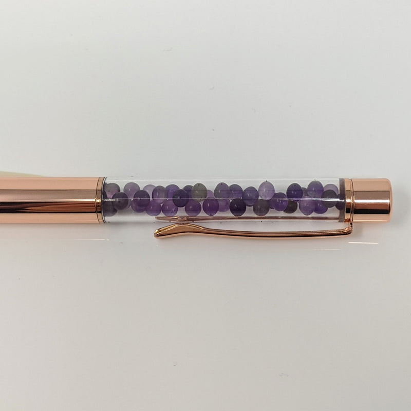 Close-up of Amethyst crystal chamber in rose gold pen.