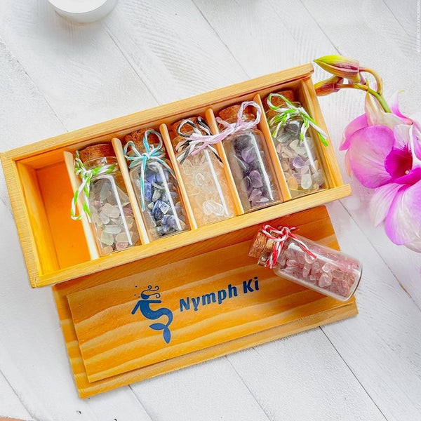 Open wooden box with crystal-filled jars and orchid flower, styled for sacred gifting and meditation rituals.
