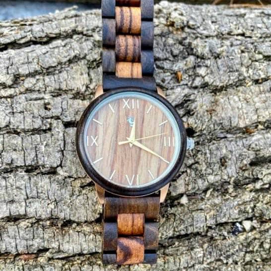 Nymph Ki Ebony and Zebrawood watch on a log.