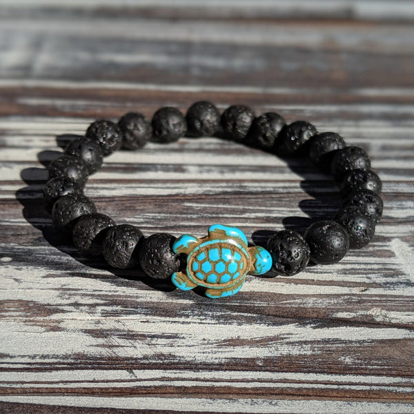 Lava rock aromatherapy bracelet with turquoise turtle charm on wood background.