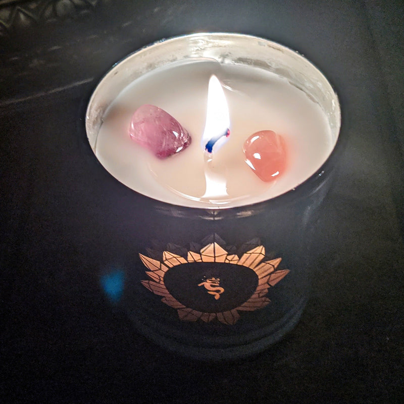 Lemongrass crystal candle burning with embedded crystals and mermaid emblem.