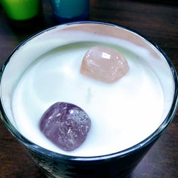 Amethyst and rose quartz crystals embedded in soy wax inside a luxury candle jar.