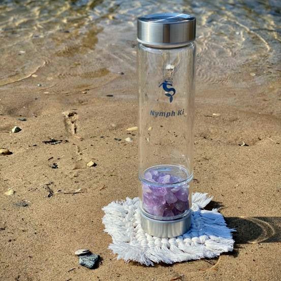 Single macrame coaster holding a Crystal Ki Water bottle, showcasing its use.