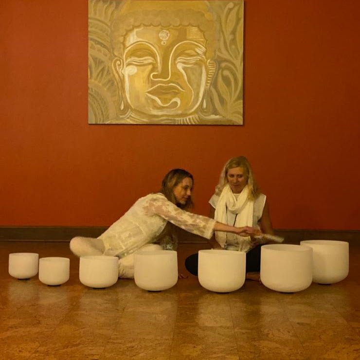 Sound healing session using quartz bowls under warm studio lighting.