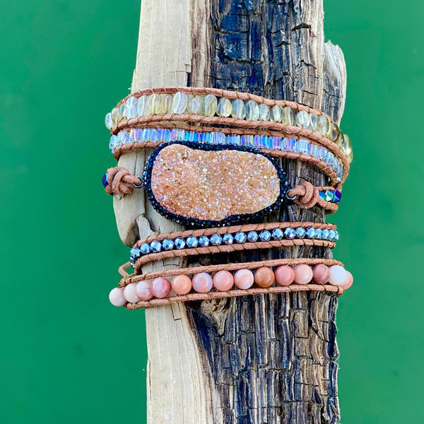 Champagne Druzy Quartz wrap bracelet with iridescent beads and pink accents, styled on wood.

