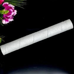  White suede mallet for crystal singing bowls resting near a pink flower.