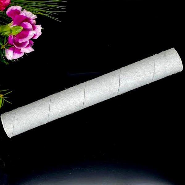  White suede mallet for crystal singing bowls resting near a pink flower.