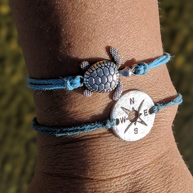 True North turtle bracelet with compass and sea turtle charms shown stacked on wrist.